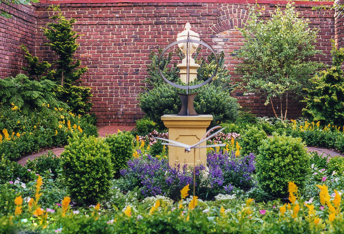 A mix of evergreens and annuals sets off a sundial. : Georgetown, Capitol Hill, and NW Gardens : CITYSCAPES® Landscaping LLC