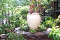 A border of field stone and a tall planter give vertical interest in this garden.