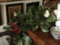 Faux Magnolia and evergreen garland graces a sideboard.