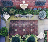 A patterned rectangle of brick with flagstone insets defines a seating area.
