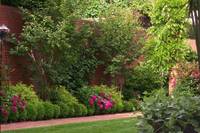 Huge brick walls softened with layers of trees, shrubs and perennials.